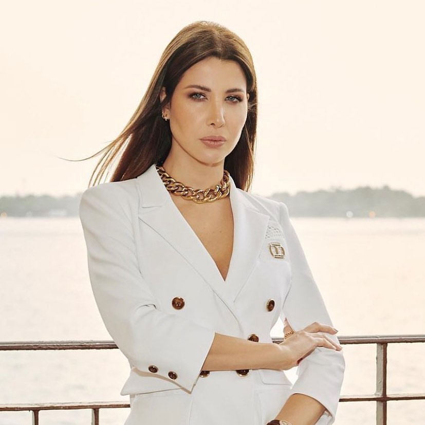 Nancy Ajram in a white jacket and gold chain