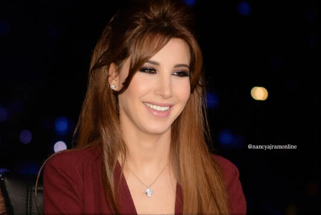 Nancy Ajram smiling in burgundy